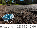 Discarded Medical Face Mask at the Side of a Road 134424240