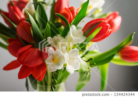 Spring floral background. Red tulips and Fresia white flower bouquet. Copy space Spring floral background. Red tulips and Fresia white flower bouquet. Copy space 134424344