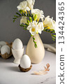 Spring, Easter background. White freesias flowers in a vase with white eggs. 134424365