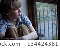 Sad Depressed Boy Young Male Child Looking Out of a Window 134424381