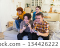 Home party. Cheerful group of friends playing video games at home. Happy diverse group buddies having fun together indoor. Friendship leisure entertainment concept. Young best friends enjoying weekend 134426222
