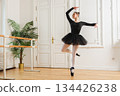 Young ballerina in tutu skirt dancing practicing ballet positions in dance class. Young classical dancer woman in dance studio. Ballet class training. Performer girl rehearsing dance in ballet school 134426238