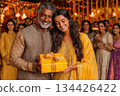 Smiling man and woman holding gift box during festive celebration together 134426422
