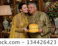 Joyful celebration with cake and traditional attire in elegant setting 134426423