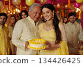 Joyful celebration with cake and family in vibrant festive attire 134426425