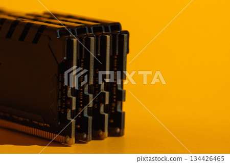 Macro view of stacked RAM module ends on yellow background Macro view of stacked RAM module ends on yellow background 134426465