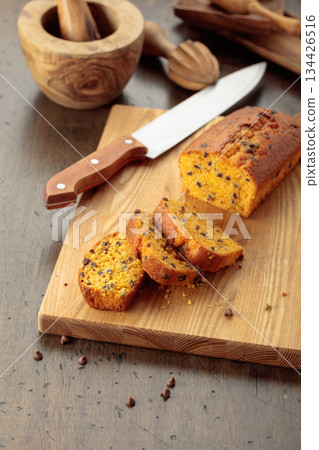 Cake with chocolate pieces on a kitchen table. 134426516