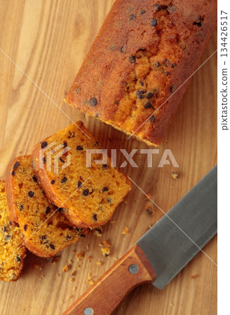 Cake with chocolate pieces on a kitchen table. 134426517