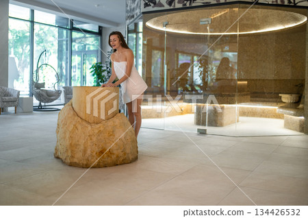 Excited young woman in a towel preparing for the spa salt therapy in spa center Excited young woman in a towel preparing for the spa salt therapy in spa center 134426532