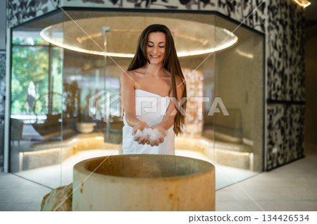 Excited young woman in a towel preparing for the spa salt therapy in spa center 134426534