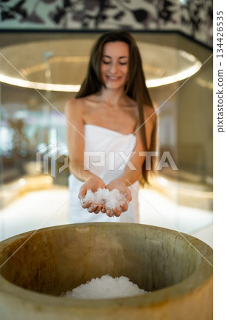 Excited young woman in a towel preparing for the spa salt therapy in spa center Excited young woman in a towel preparing for the spa salt therapy in spa center 134426535