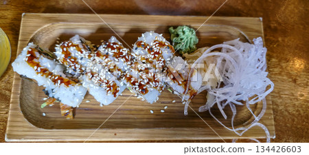 Sushi rolls with sesame seeds and wasabi on wooden serving platter 134426603