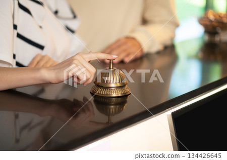 Close up picture of a hand ringing a reception bell 134426645