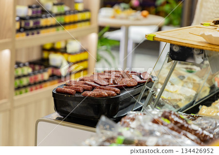 Freshly prepared meat products displayed in a modern food market setting 134426952