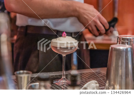 Bartender preparing cocktail with elegant glass and decorative garnish Bartender preparing cocktail with elegant glass and decorative garnish 134426964