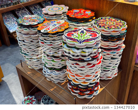 Stacks of hand painted Turkish ceramic coasters with floral ornaments. Traditional craft, decorative art, cultural heritage, souvenir production, handmade goods, ethnic design and retail presentation Stacks of hand painted Turkish ceramic coasters with floral ornaments. Traditional craft, decorative art, cultural heritage, souvenir production, handmade goods, ethnic design and retail presentation 134427010