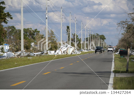 Metallic scrap rubbish on roadside from hurricane severely damaged houses in Florida residential area. Aftermath of natural disaster Metallic scrap rubbish on roadside from hurricane severely damaged houses in Florida residential area. Aftermath of natural disaster 134427264