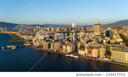Aerial view of Izmir city skyline along the coastline with urban buildings, waterfront, sea and distant mountains. Turkey. Aerial view of Izmir city skyline along the coastline with urban buildings, waterfront, sea and distant mountains. Turkey. 134427353