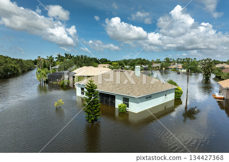 Flooding in Florida caused by tropical storm from hurricane rainfall. Suburb houses in residential community surrounded by flood waters. Aftermath of natural disaster Flooding in Florida caused by tropical storm from hurricane rainfall. Suburb houses in residential community surrounded by flood waters. Aftermath of natural disaster 134427368