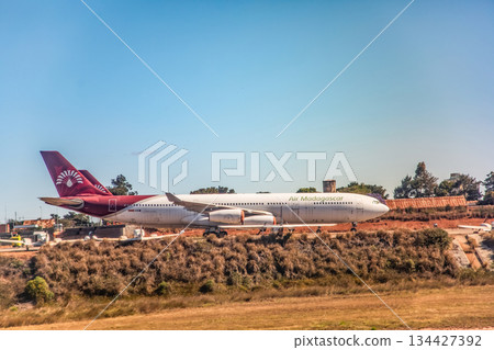 Antananarivo, Madagascar - October 05, 2023: Air Madagascar airplane on runway with clear blue sky backdrop Antananarivo, Madagascar - October 05, 2023: Air Madagascar airplane on runway with clear blue sky backdrop 134427392