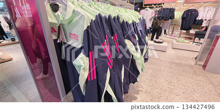 Berlin, Germany - September 19, 2025: Adidas sportswear display with colorful jackets in retail store 134427496