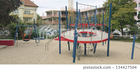 Berlin, Germany - September 25, 2025: Modern playground with climbing structure and swings in urban setting 134427504