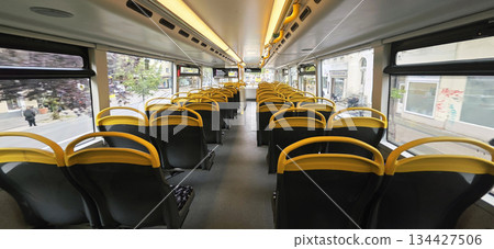 Berlin, Germany - September 25, 2025: Interior view of empty city bus with yellow and black seating design Berlin, Germany - September 25, 2025: Interior view of empty city bus with yellow and black seating design 134427506