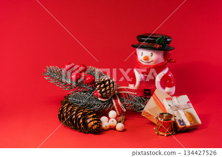 Festive Snowman and Pine Cones on Red Christmas Background Festive Snowman and Pine Cones on Red Christmas Background 134427526