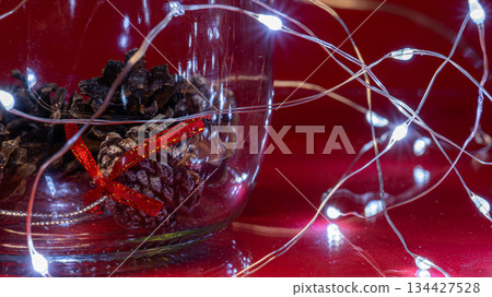 Christmas Pine Cones and Lights on Red Background Christmas Pine Cones and Lights on Red Background 134427528