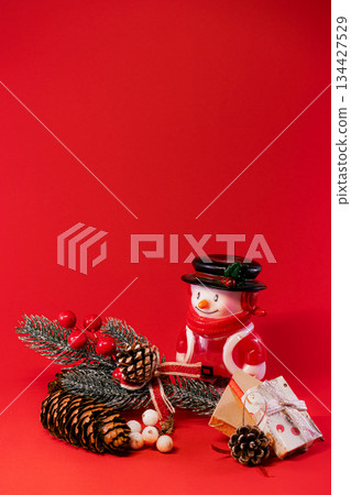 Festive Snowman and Pine Cones on Red Christmas Background Festive Snowman and Pine Cones on Red Christmas Background 134427529