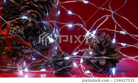 Christmas Pine Cones and Lights on Red Background Christmas Pine Cones and Lights on Red Background 134427535