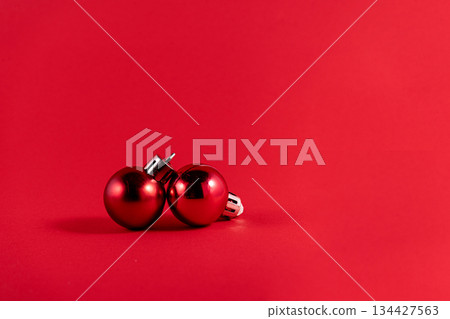Minimalist Christmas Composition with Two Red Ornaments on Red Background Minimalist Christmas Composition with Two Red Ornaments on Red Background 134427563
