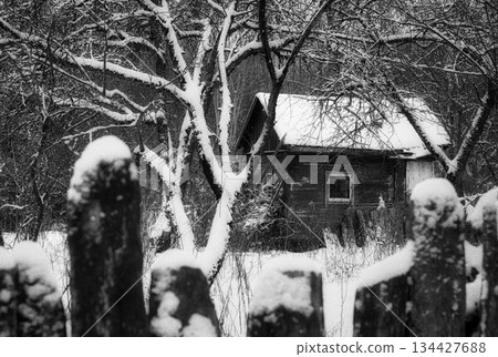 Traditional wooden house in the middle of the orchard in winter 134427688