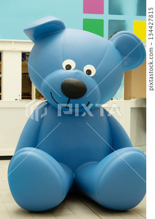 Berlin, Germany - September 09, 2025: Large blue teddy bear sitting in colorful room Berlin, Germany - September 09, 2025: Large blue teddy bear sitting in colorful room 134427815