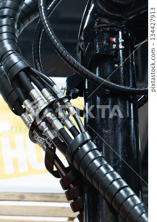 Berlin, Germany - January 22, 2024: Hydraulic hoses and connectors on industrial machinery Berlin, Germany - January 22, 2024: Hydraulic hoses and connectors on industrial machinery 134427913