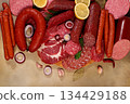 An assortment of various types of sausages, smoked meats, salami, and game sausages with lemon, spices, and herbs on a concrete table. Advertising and banner for a store, menu for a cafe or restaurant 134429188