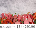 Selection of various smoked and dry-cured sausages, sliced salami, and spices on a kitchen counter. Advertising and menu for a store, banner for a cafe or restaurant. 134429190