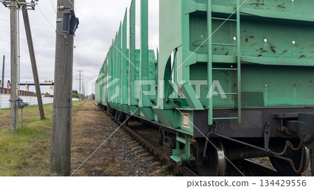 Empty timber cars close up. Railroad cars loaded with timber on the tracks. Timber trade. Freight transport. Empty timber cars close up. Railroad cars loaded with timber on the tracks. Timber trade. Freight transport. 134429556
