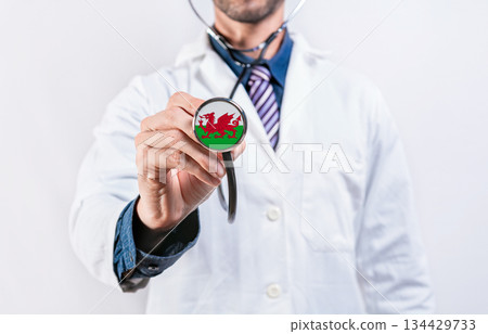 Wales healthcare system, doctor holding stethoscope. Wales health and medical insurance concept Wales healthcare system, doctor holding stethoscope. Wales health and medical insurance concept 134429733