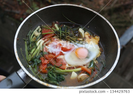 Fried eggs with spinach and pumpkin,shalots  in a frying pan- healthy eating 134429763