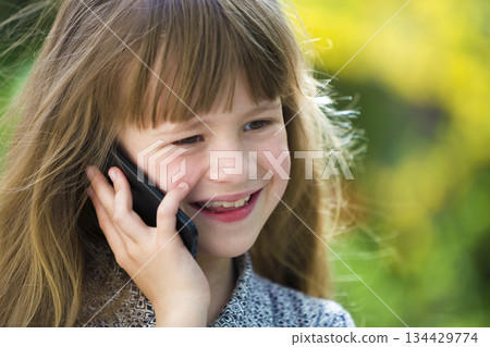 Cute child young girl talking on cellphone outdoors. Children and modern technology, communication concept. 134429774