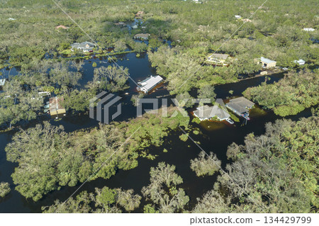Consequences of natural disaster. Heavy flood with high water surrounding residential houses after hurricane Ian rainfall in Florida residential area Consequences of natural disaster. Heavy flood with high water surrounding residential houses after hurricane Ian rainfall in Florida residential area 134429799