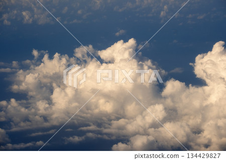 Cloudy sky, from airplane window point of view. View from above at high altitude of dense puffy cumulus clouds 134429827