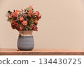 a bouquet of dried roses and wildflowers arranged in a handmade ceramic vase 134430725