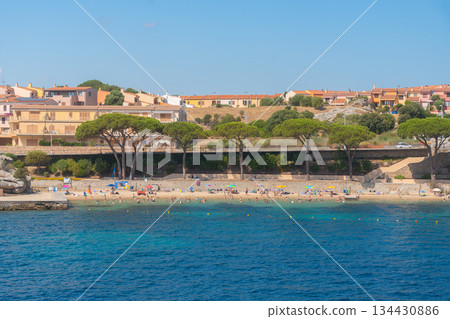 Beachfront area with coastal town buildings and calm blue sea. Summer vacation, seaside lifestyle and travel destination, Palau, Italy Beachfront area with coastal town buildings and calm blue sea. Summer vacation, seaside lifestyle and travel destination, Palau, Italy 134430886