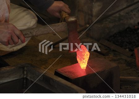 Red-hot steel being folded and forged 134431018