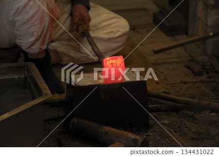 Red-hot steel being folded and forged 134431022