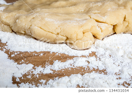 Close Up of Raw Pastry Dough on Floured Wooden Surface 134431034