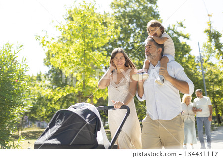 Multi-generational family walking together enjoying park stroll 134431117