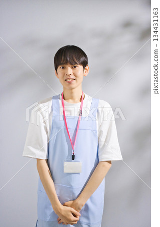 A male nursery teacher in his 20s wearing an apron A male nursery teacher in his 20s wearing an apron 134431163